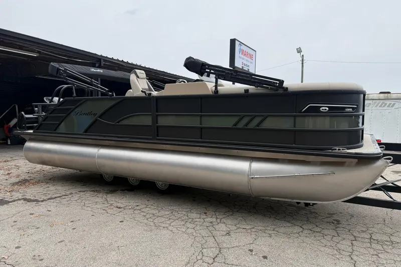 Slide: The Image of 2026 Bentley Pontoons Elite 223 Swingback pontoon boat on a trailer, parked outdoors. - 3