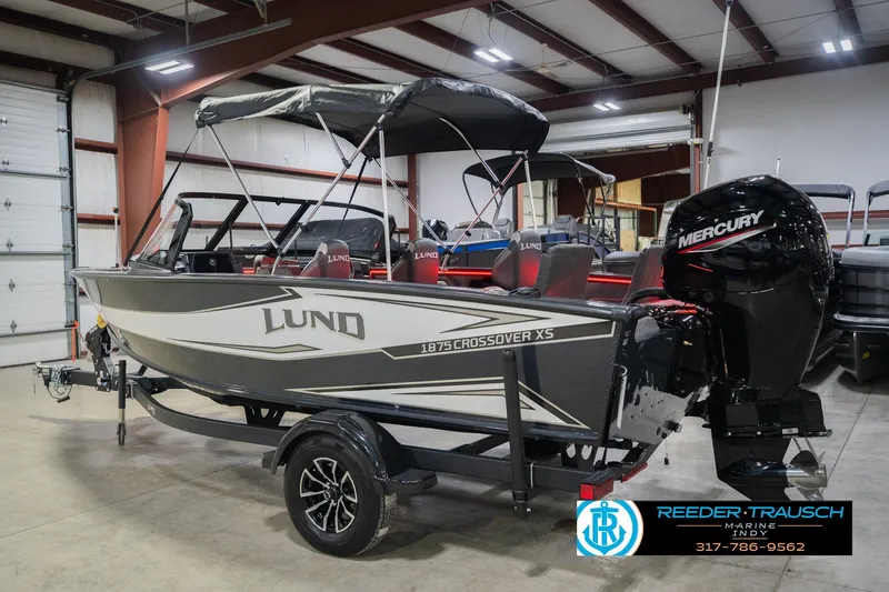 Slide: The Image of 2026 Lund 1875 Crossover XS boat in showroom, featuring sleek design and spacious interior. - 10