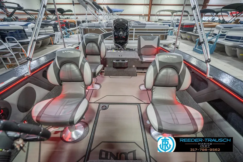 Slide: The Image of 2026 Lund 1875 Crossover XS boat interior with red LED lighting in showroom. - 20