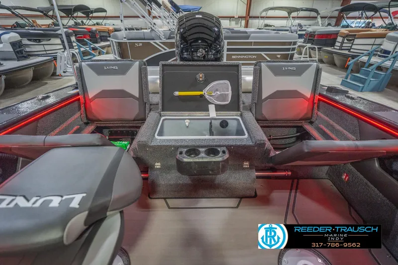Slide: The Image of 2026 Lund 1875 Crossover XS boat interior with storage compartments and red LED lighting. - 23