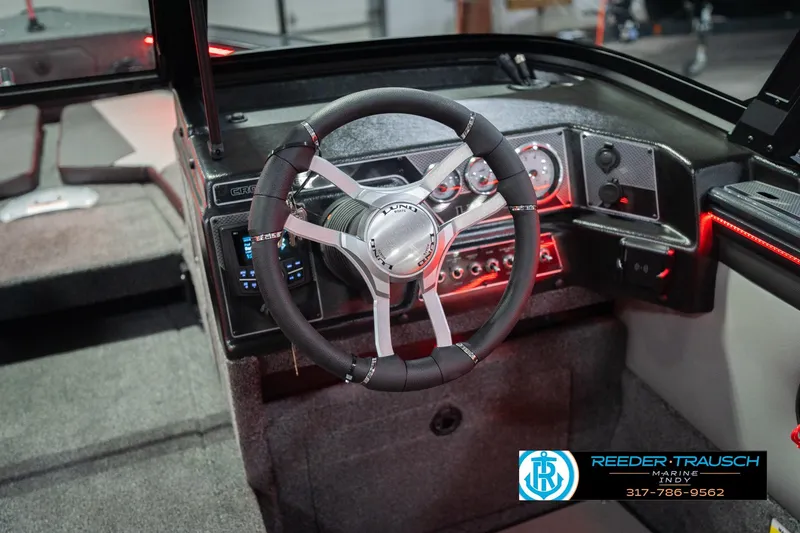 Slide: The Image of 2026 Lund 1875 Crossover XS boat dashboard with Rockford Fosgate audio system displaying FM tuner. - 32