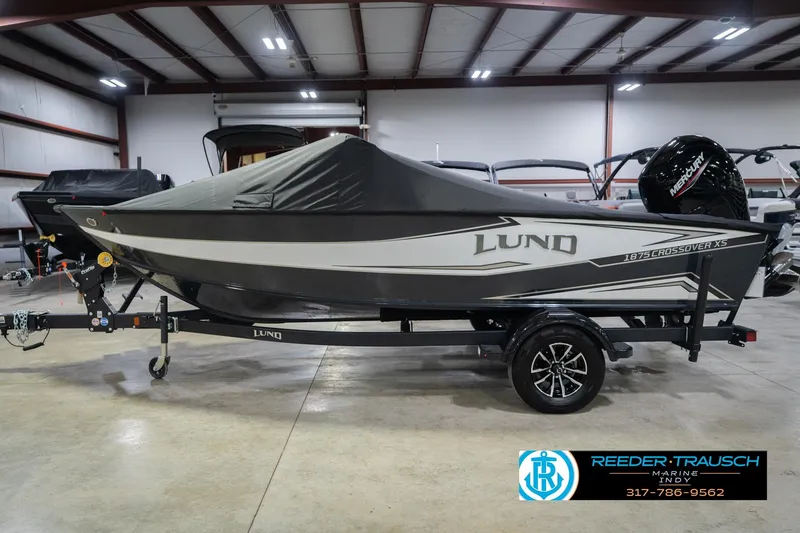 Slide: The Image of 2026 Lund 1875 Crossover XS boat detail with cleat and cap, Reeder-Trausch Marine logo visible. - 58