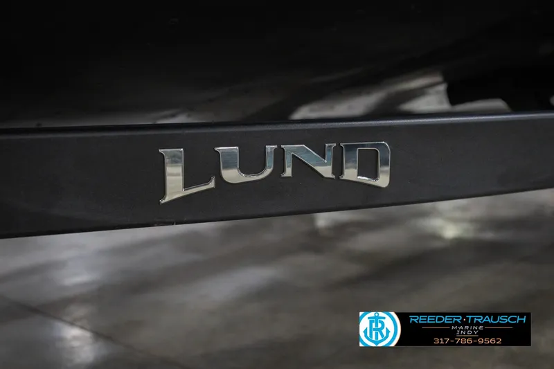 Slide: The Image of 2026 Lund 1875 Crossover XS boat logo on black surface. - 63