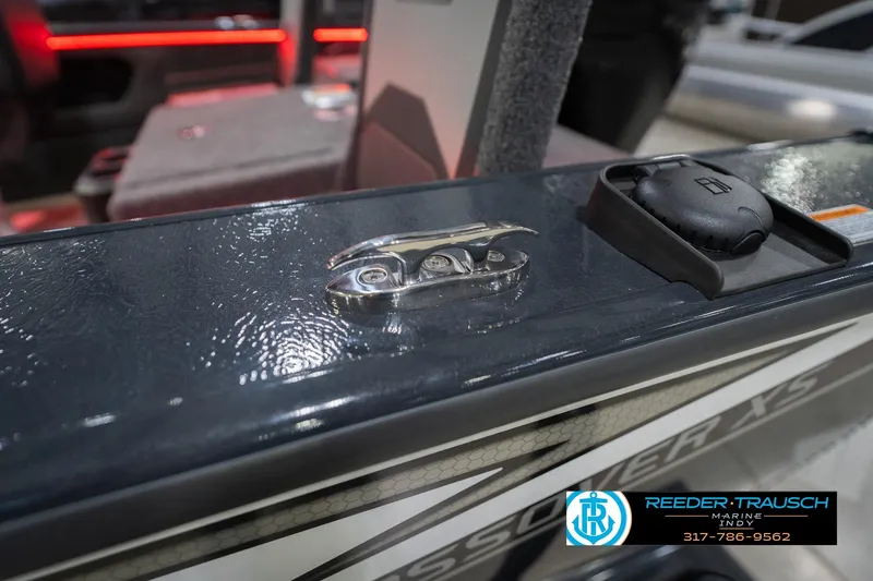Slide: The Image of 2026 Lund 1875 Crossover XS boat detail with cleat and cap, Reeder-Trausch Marine logo visible. - 66