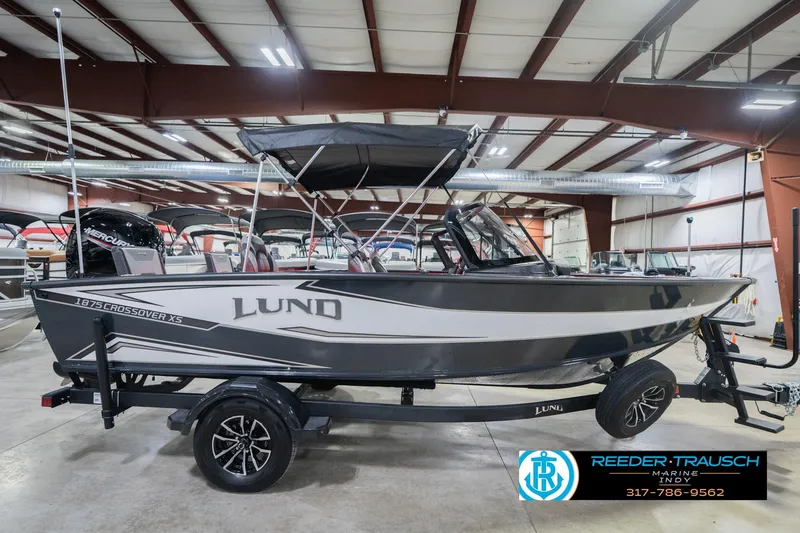 Slide: The Image of 2026 Lund 1875 Crossover XS boat with 150 HP engine in showroom. - 7