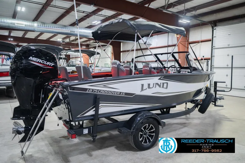 Slide: The Image of 2026 Lund 1875 Crossover XS boat with Mercury engine in showroom. - 8
