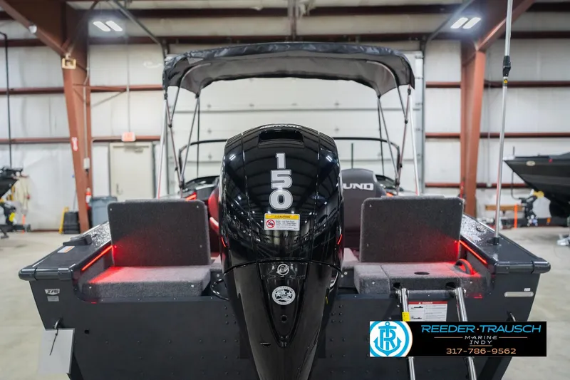 Slide: The Image of 2026 Lund 1875 Crossover XS boat in showroom, featuring sleek design and Mercury engine. - 9