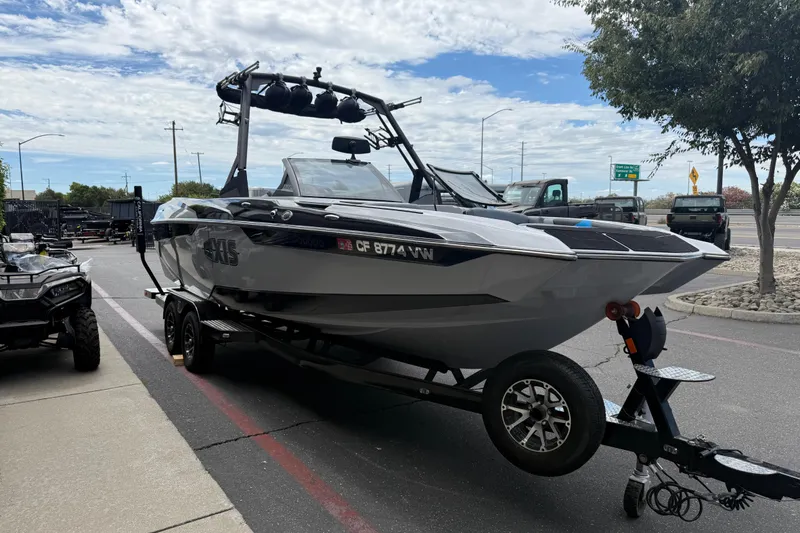 Slide: The Image of 2023 Axis A24 boat on trailer, parked outdoors under a cloudy sky. - 6