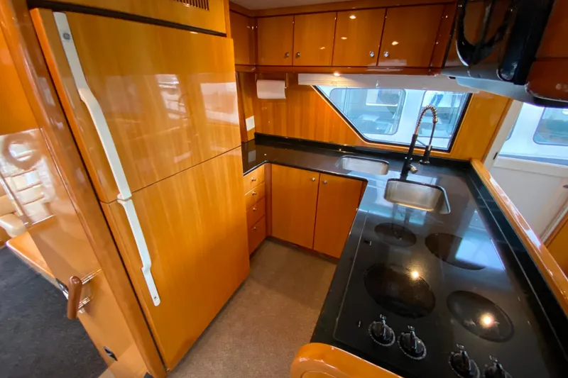 Slide: The Image of Luxurious kitchen in 2001 Compass 57 yacht with sleek wood cabinetry and modern appliances. - 11