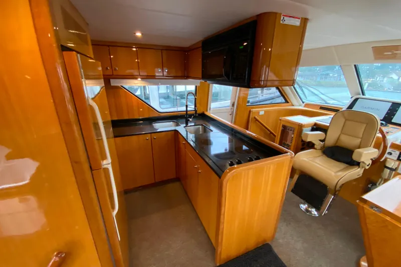 Slide: The Image of Luxurious 2001 Compass 57 yacht interior with modern kitchen and navigation area. - 13