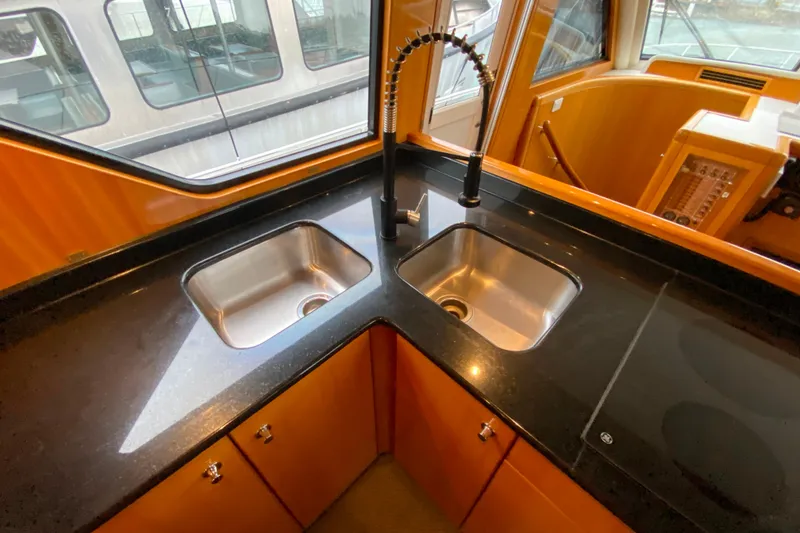 Slide: The Image of Luxurious kitchen area on a 2001 Compass 57 yacht with dual sinks and sleek countertops. - 15