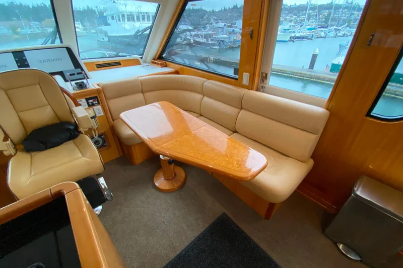 Slide: The Image of Luxurious interior of 2001 Compass 57 yacht with leather seating and wooden table. - 18