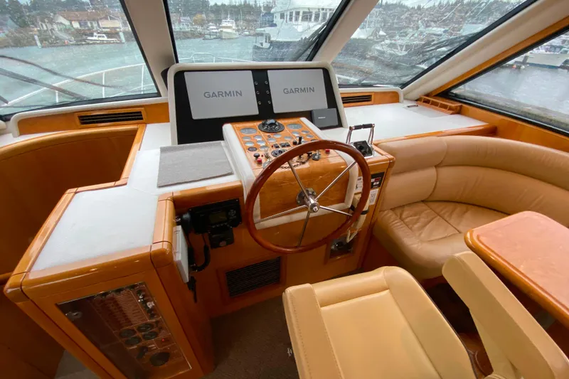 Slide: The Image of Luxurious 2001 Compass 57 yacht helm with Garmin navigation and plush seating. - 19