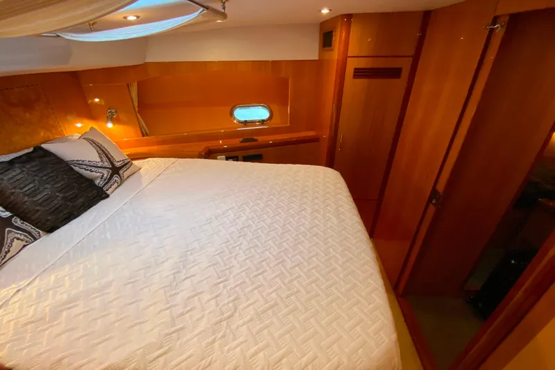 Slide: The Image of Luxurious bedroom interior of 2001 Compass 57 yacht with elegant wood paneling. - 44