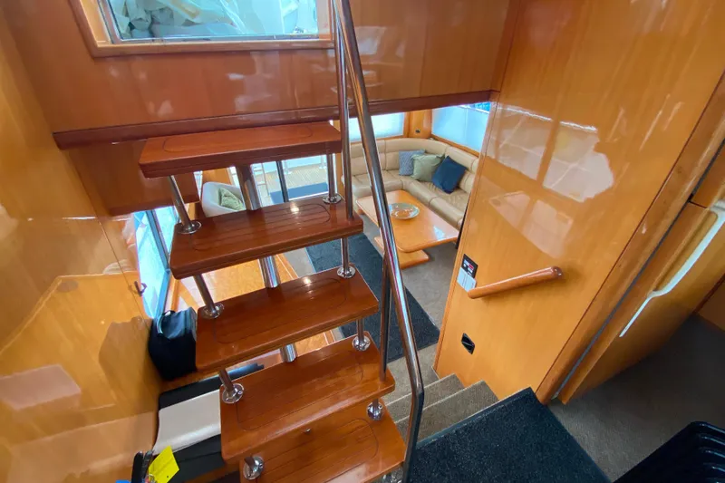 Slide: The Image of Interior of 2001 Compass 57 yacht with wooden stairs and cozy seating area. - 49