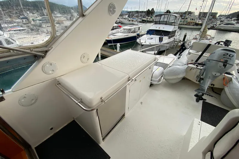 Slide: The Image of 2001 Compass 57 yacht deck with storage and outboard motor, docked at marina. - 53