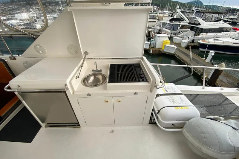 Slide: The Image of Outdoor kitchen on a 2001 Compass 57 yacht with sink and grill at marina. - 54