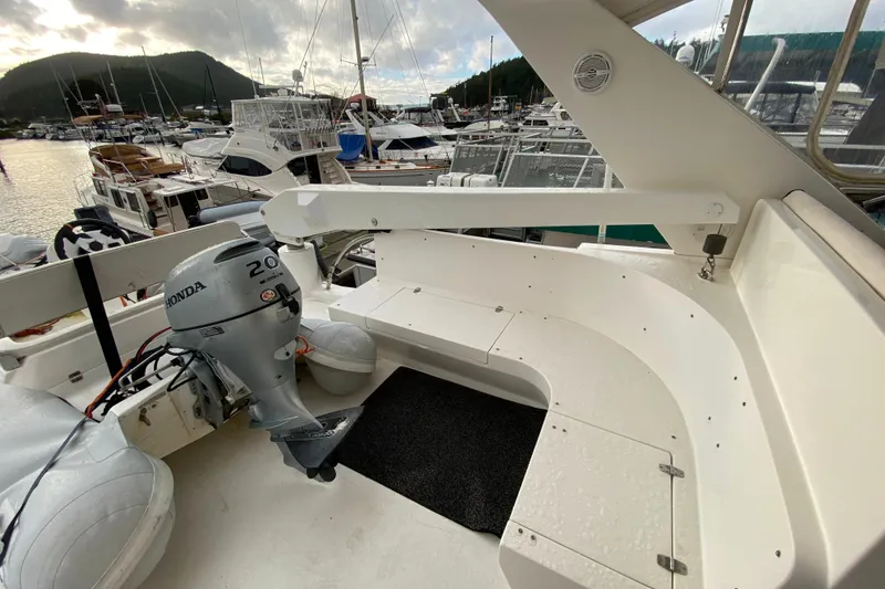 Slide: The Image of Boat deck with Honda outboard motor, surrounded by marina and yachts, Compass 57 model, 2001. - 56