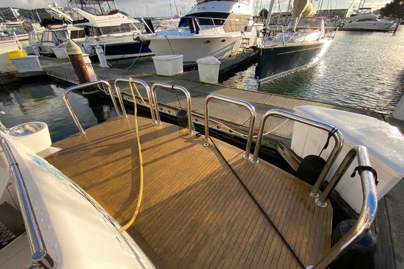 Slide: The Image of Boat docked at marina with wooden deck, Compass 57 model, 2001. - 71