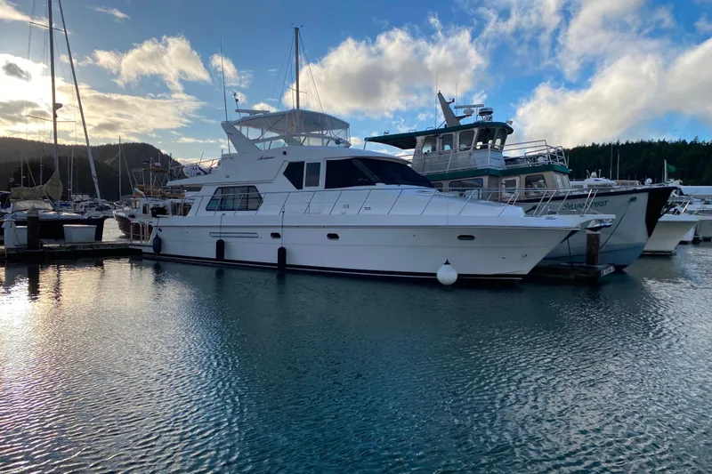 Slide: The Image of Luxurious 2001 Compass 57 yacht docked in a serene marina setting. - 78