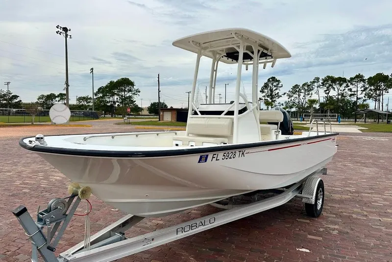 Slide: The Image of 2023 Boston Whaler 210 Montauk boat on trailer, parked on brick pavement. - 4