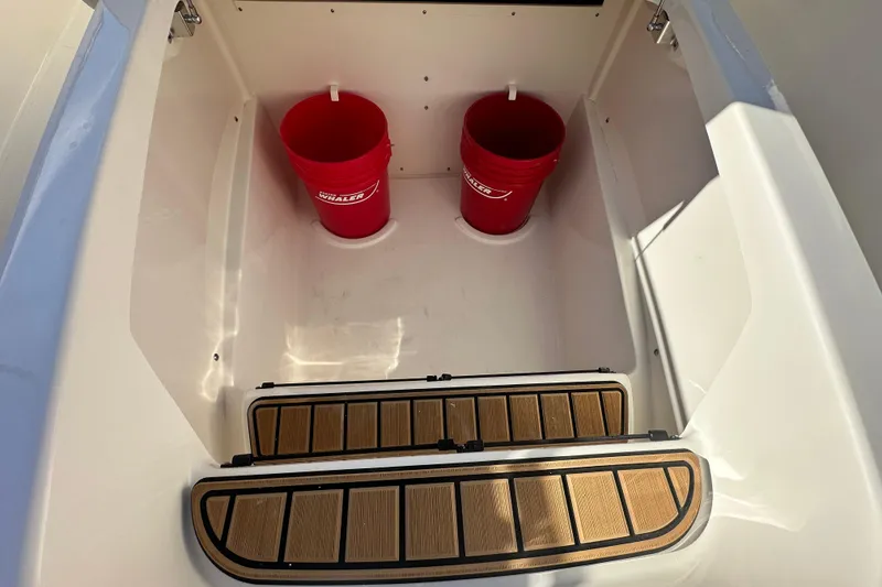 Slide: The Image of Boston Whaler 280 Outrage 2026 with red buckets in storage area. - 16