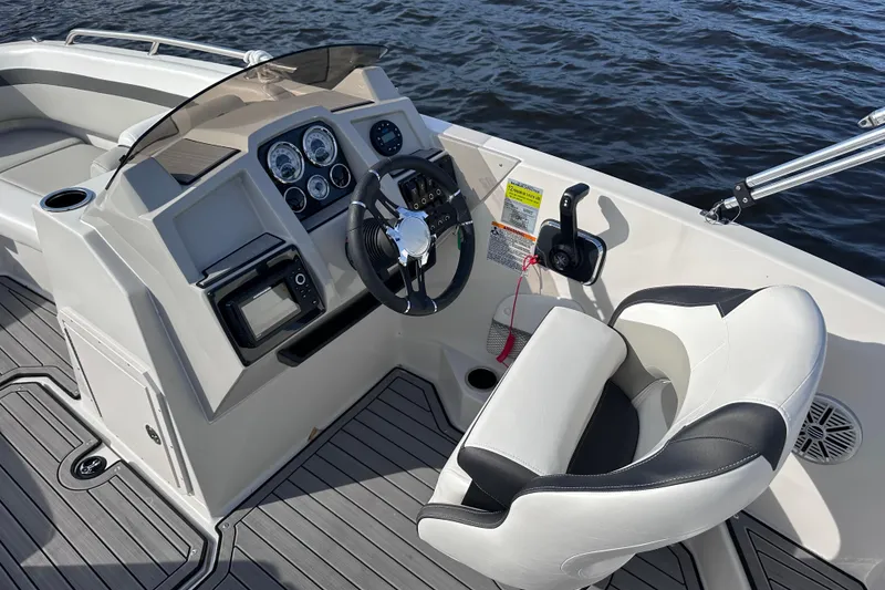 Slide: The Image of 2023 Starcraft SVX 191 OB boat cockpit with steering wheel and controls on water. - 11