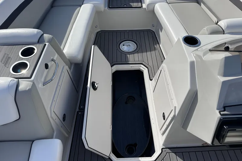 Slide: The Image of 2023 Starcraft SVX 191 OB boat interior with open storage compartment and cup holders. - 14