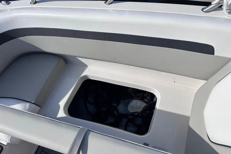 Slide: The Image of 2023 Starcraft SVX 191 OB boat storage compartment with open hatch and visible ropes. - 19