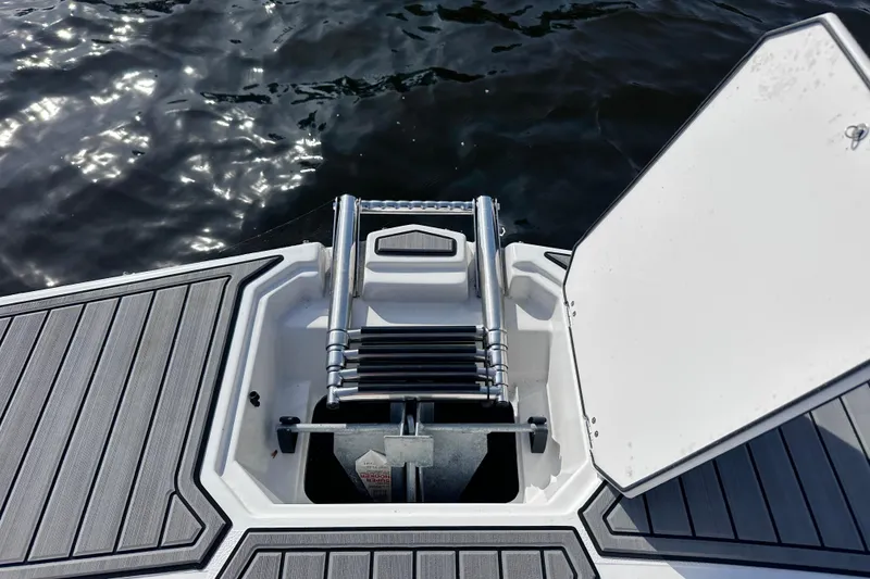 Slide: The Image of 2023 Starcraft SVX 191 OB boat ladder and deck, with water in the background. - 21