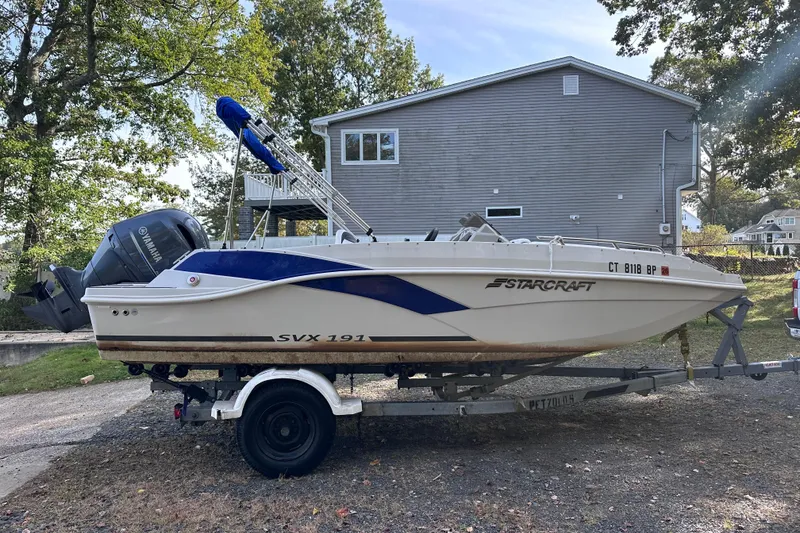 Slide: The Image of 2023 Starcraft SVX 191 OB boat on trailer, parked near a house. - 25