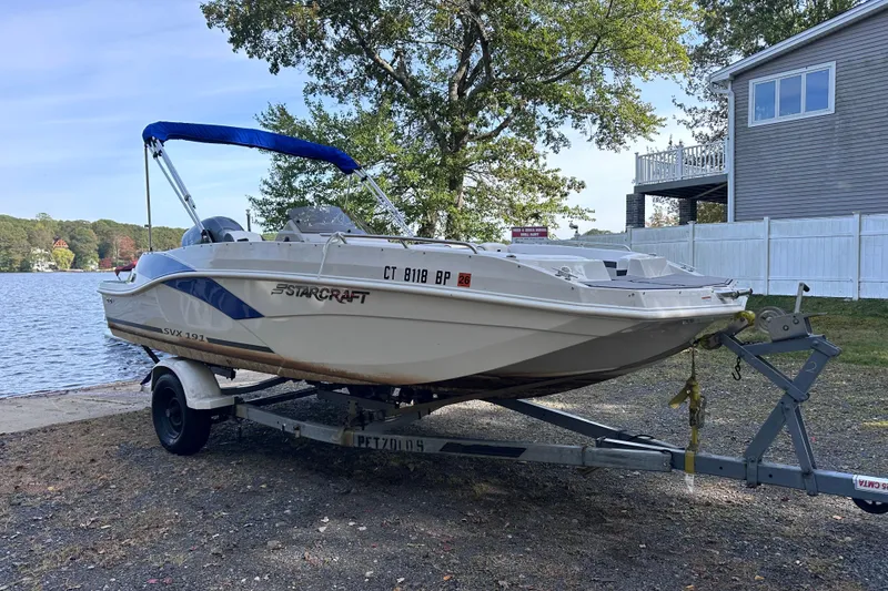 Slide: The Image of 2023 Starcraft SVX 191 OB boat on trailer by a lakeside house. - 26
