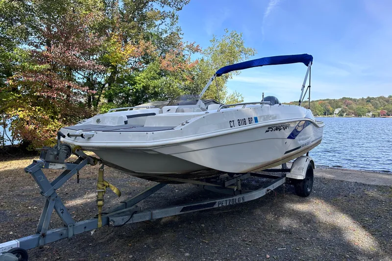 Slide: The Image of 2023 Starcraft SVX 191 OB boat on trailer by a scenic lake. - 27