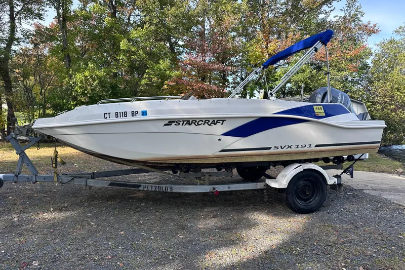 Slide: The Image of 2023 Starcraft SVX 191 OB boat on trailer, surrounded by trees. - 28