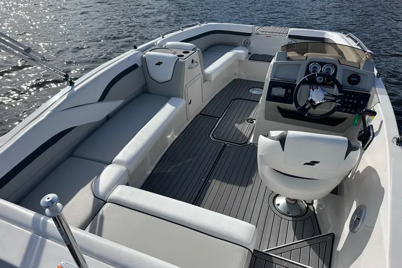 Slide: The Image of 2023 Starcraft SVX 191 OB boat interior with seating and steering console on water. - 4