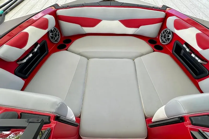 Slide: The Image of 2021 Axis A20 boat interior with red and white seating, cup holders, and speakers. - 46