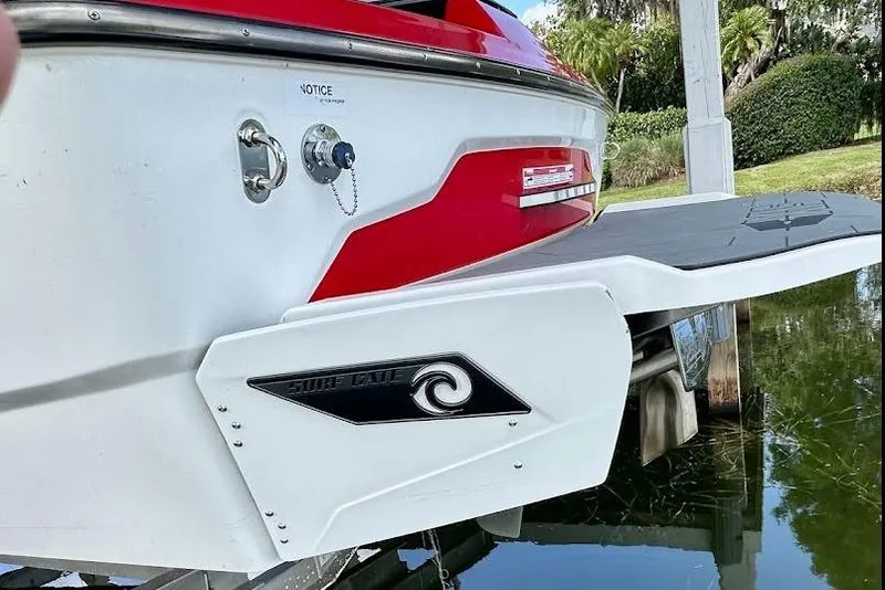 Slide: The Image of 2021 Axis A20 boat with Surf Gate feature, docked near lush greenery. - 5