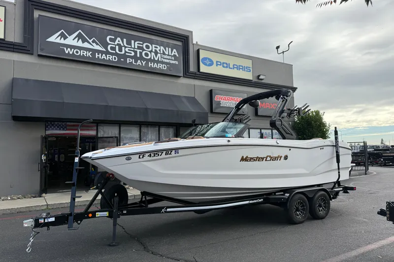 The Image of 2025 MasterCraft X24 boat on trailer outside California Custom store. - 13