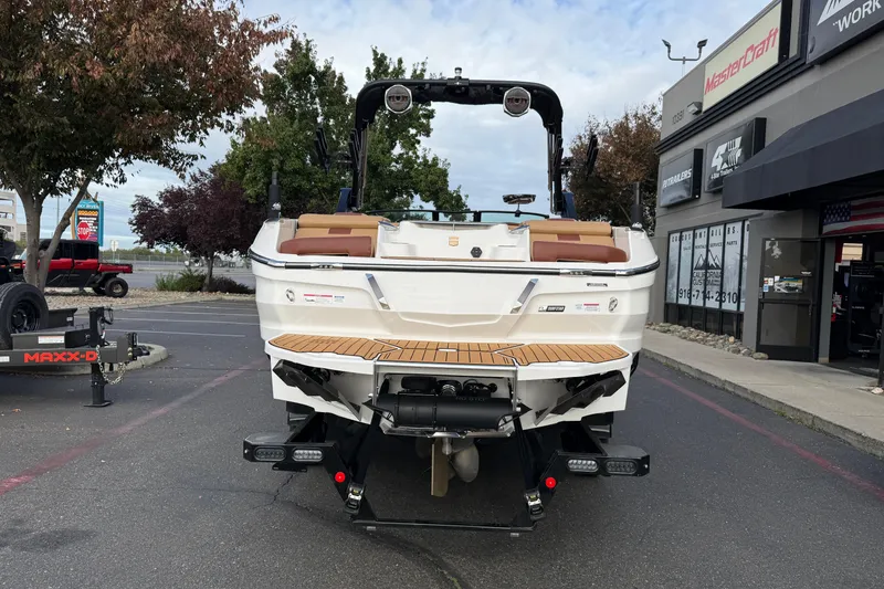 Slide: The Image of 2025 MasterCraft X24 boat parked outside dealership, rear view. - 16