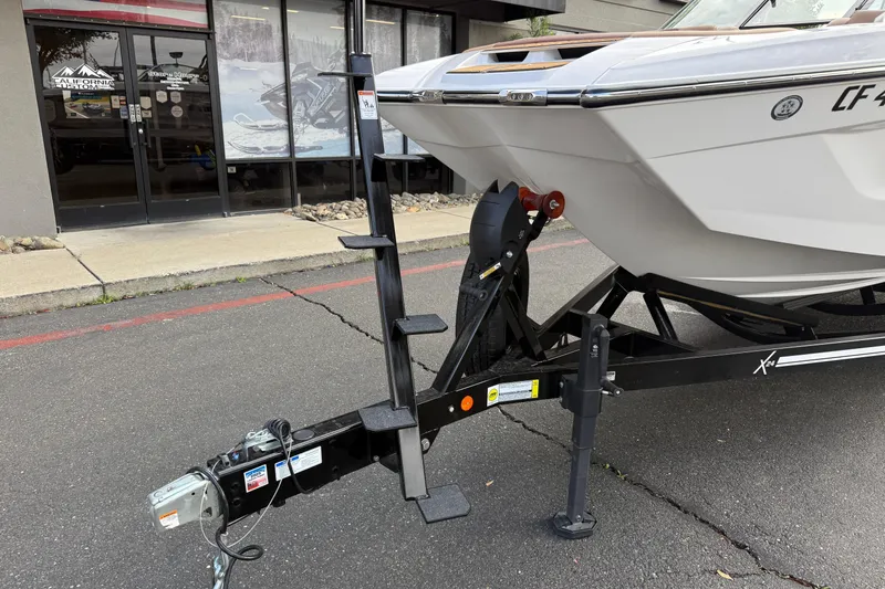 Slide: The Image of 2025 MasterCraft X24 boat on trailer outside dealership. - 21