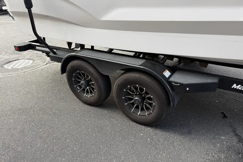 Slide: The Image of Trailer of 2025 MasterCraft X24 boat with dual wheels on asphalt. - 23