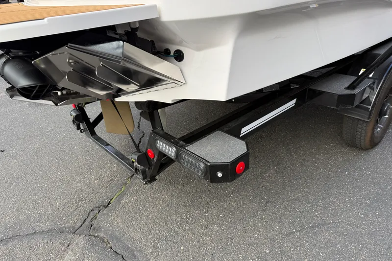 Slide: The Image of 2025 MasterCraft X24 boat trailer hitch and rear view on pavement. - 24