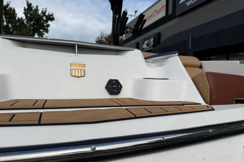 Slide: The Image of 2025 MasterCraft X24 boat with teak deck and control panel, displayed outdoors. - 27