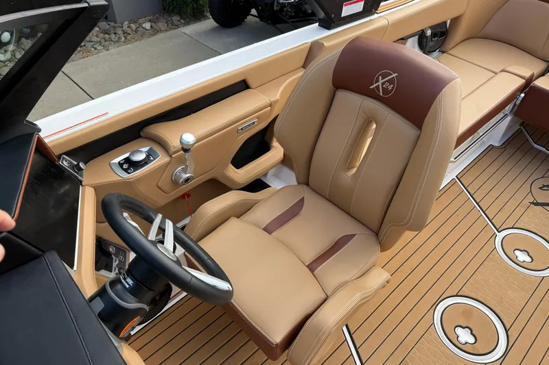 Slide: The Image of 2025 MasterCraft X24 boat interior with tan leather seating and modern controls. - 30