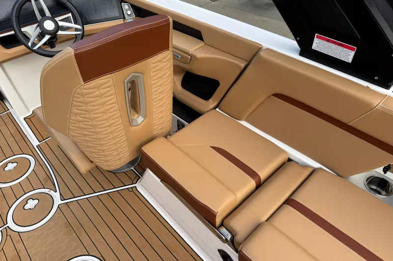 Slide: The Image of 2025 MasterCraft X24 boat interior with tan leather seats and wood-patterned flooring. - 31