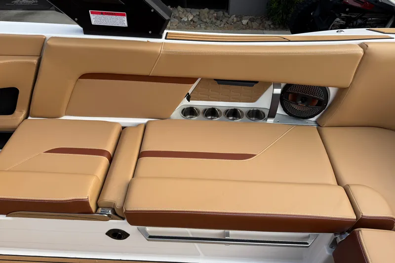 Slide: The Image of 2025 MasterCraft X24 boat interior with tan leather seating and built-in cup holders. - 32