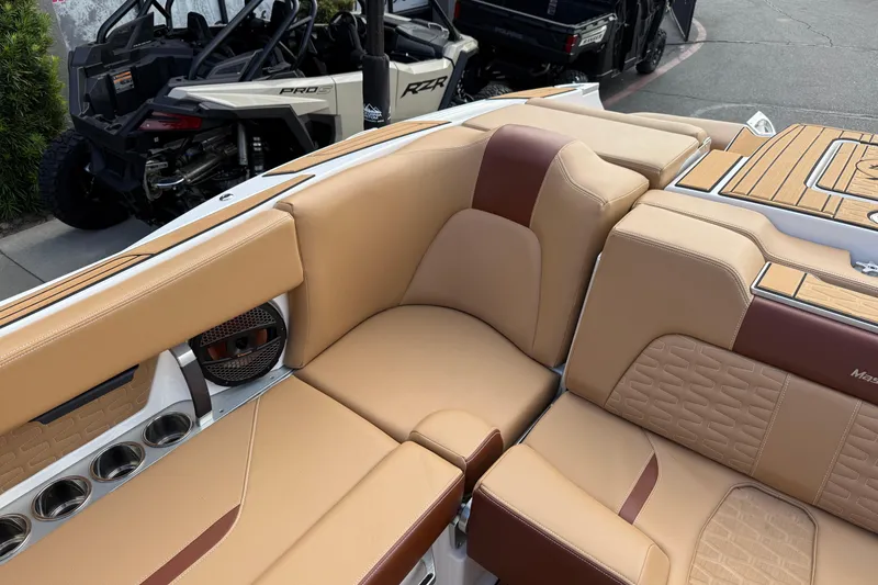 Slide: The Image of Luxurious tan interior of 2025 MasterCraft X24 boat with cup holders and speaker. - 33