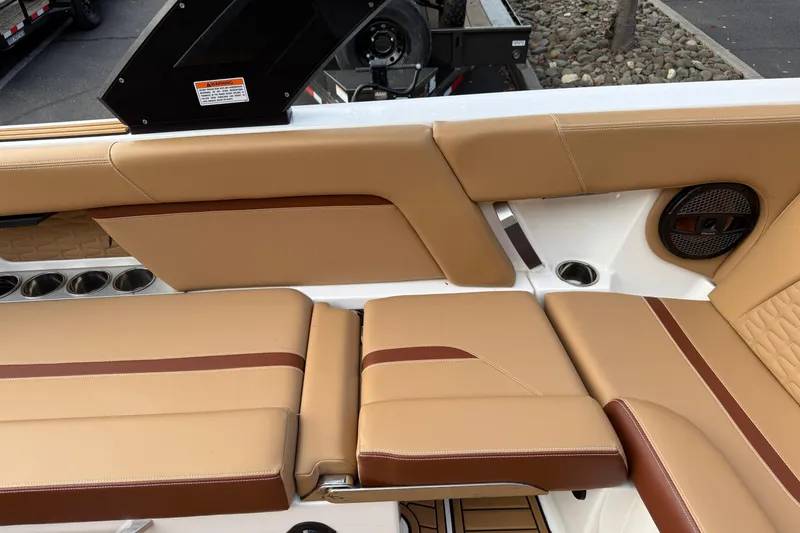 Slide: The Image of 2025 MasterCraft X24 boat interior with tan leather seating and cup holders. - 37