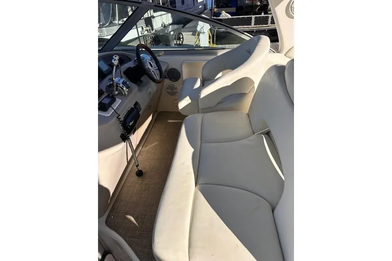 Slide: The Image of 2002 Sea Ray 340 Sundancer cockpit with beige seating and steering controls. - 13
