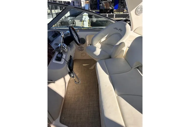 Slide: The Image of Interior of 2002 Sea Ray 340 Sundancer boat with beige seating and steering controls. - 24